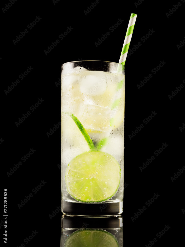 Citrus summer cold coctail or lemonad with ice on black background. Studio shot. Alcohol tasty drink. Citrus summer cold coctail or lemonad with ice on black background. Studio shot. Alcohol tasty drink.