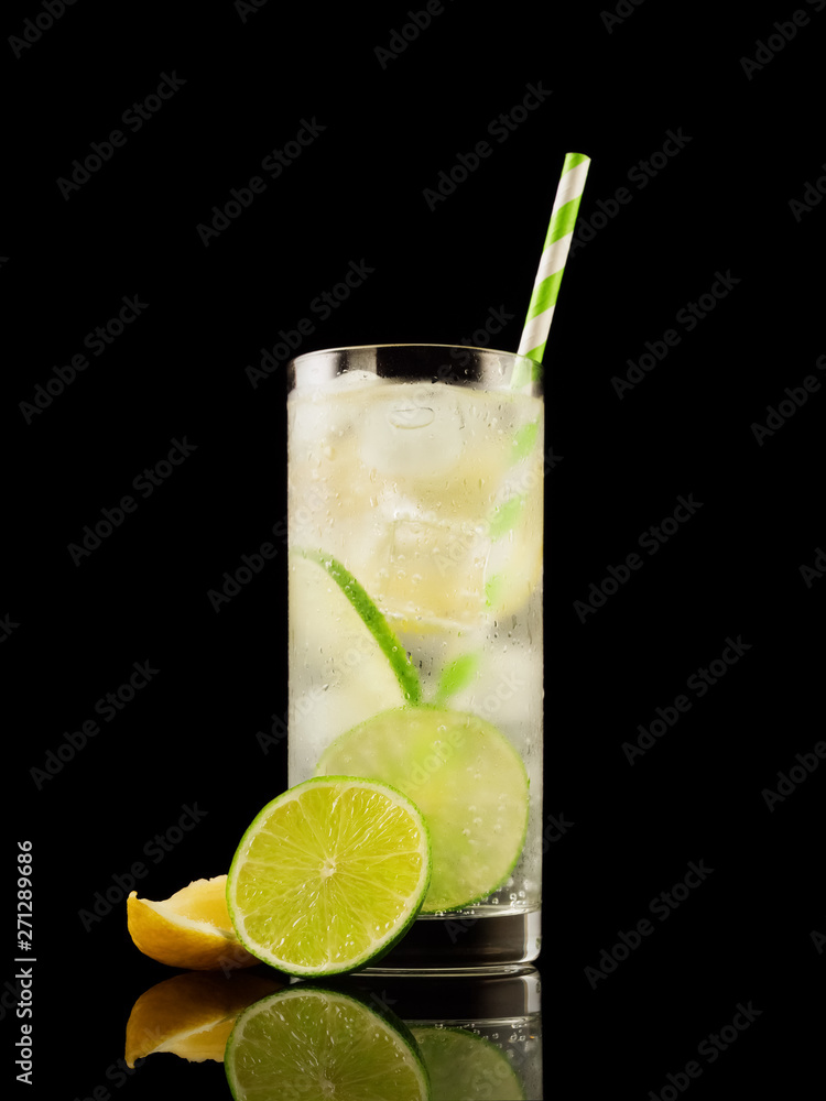 Citrus summer cold coctail or lemonad with ice on black background. Studio shot. Alcohol tasty drink. Citrus summer cold coctail or lemonad with ice on black background. Studio shot. Alcohol tasty drink.