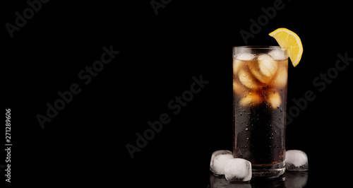 Soda with ice and lemon on black background. Sweet drink studio shoot