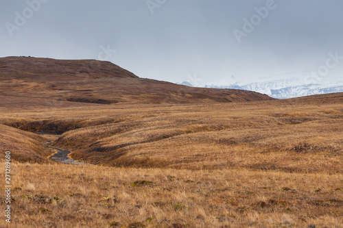 Landscape in autumn colors and mountains in the background. Peninsula Kamchatka, Russia.