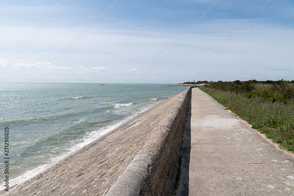 Coast and breakwater wave protection dike on Ile de Ré in France with the path