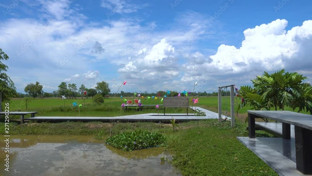 paper toy windmill in green grass field very blue sky pan from right to left hand paper toy windmill in green grass field very blue sky pan from right to left hand