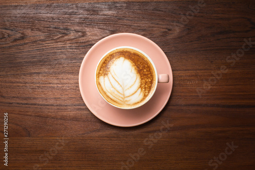 Top view. Hot coffee of cup latte art on wood table background