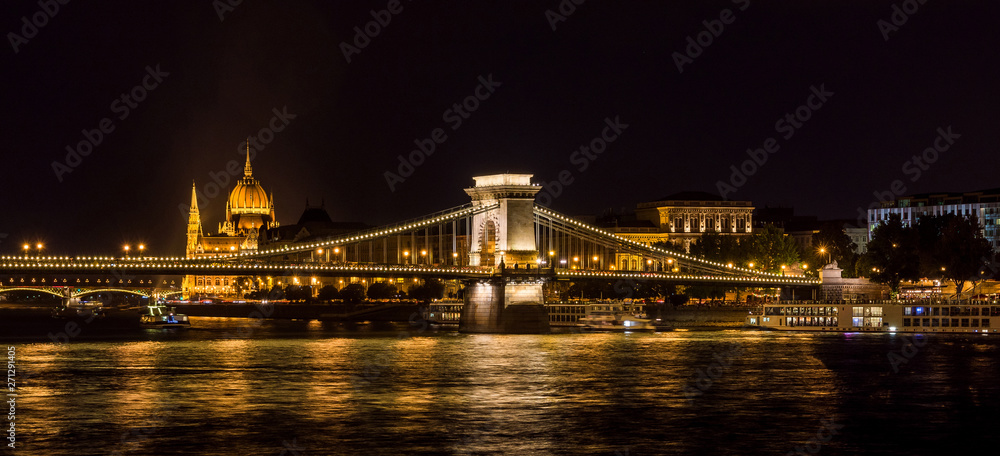 Night view of the famous Hungarian Parliament and Chain Bridge in Budapest from River Danube