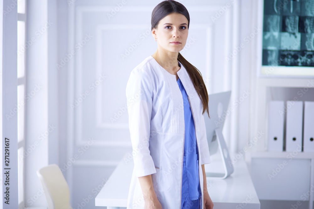 Portrait of young woman doctor in white coat standing in hospital Portrait of young woman doctor in white coat standing in hospital