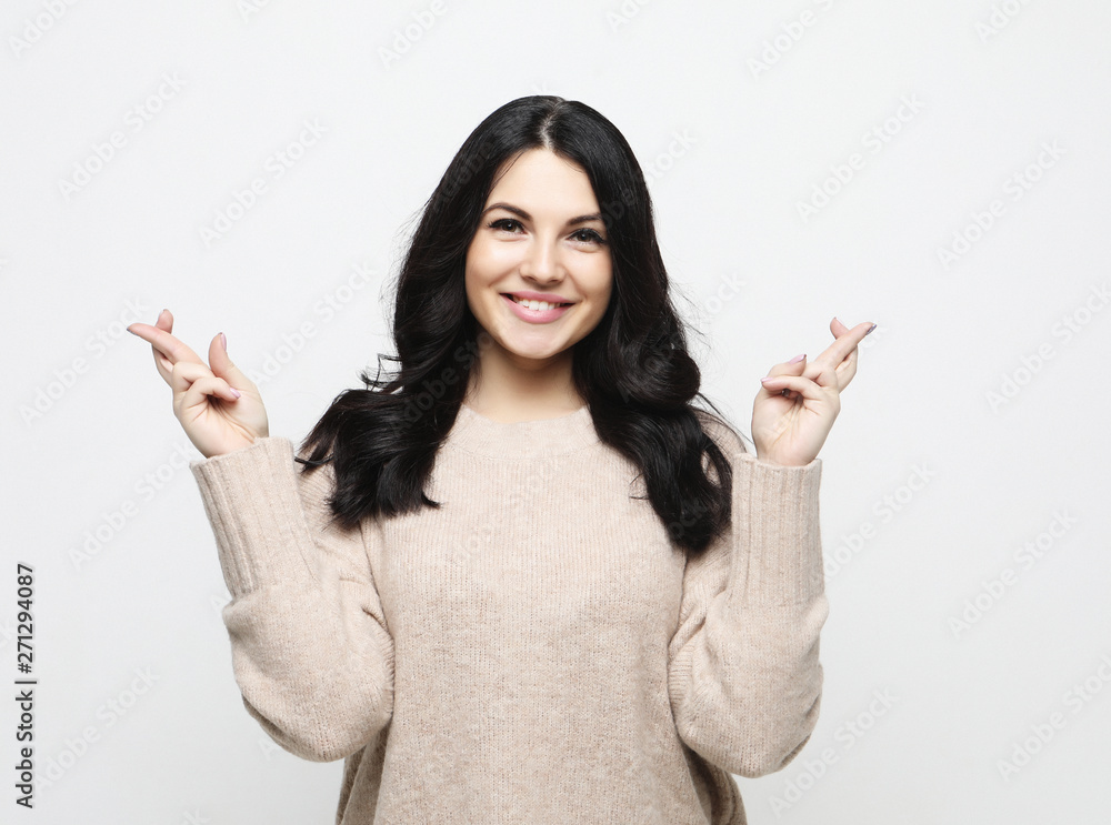 Joyful young female, raises fingers crossed, makes desirable wish. Joyful young female, raises fingers crossed, makes desirable wish.