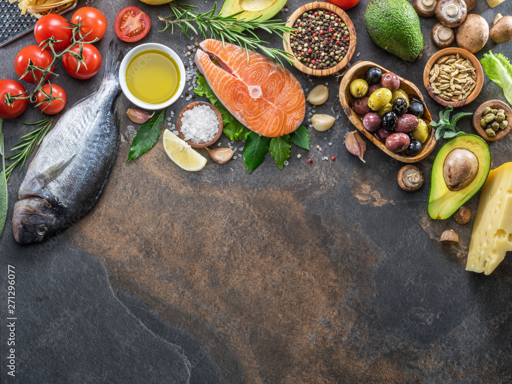 Raw dorado fish and salmon steak with spices and vegetables on the graphite board. Raw dorado fish and salmon steak with spices and vegetables on the graphite board.