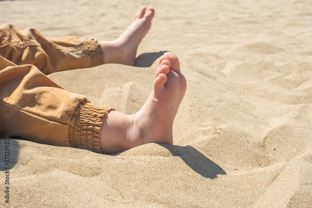 bare children's feet on the beach. close-up