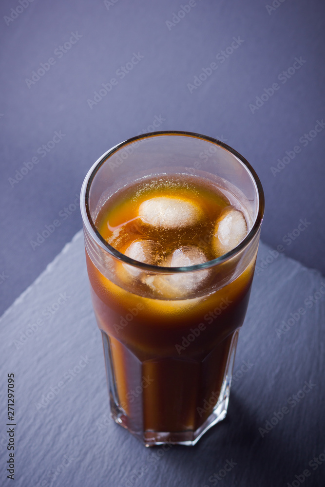 Iced coffee on a dark background. Summer drink with caffeine on the slate board. Iced coffee in a glass. Copy space Iced coffee on a dark background. Summer drink with caffeine on the slate board. Iced coffee in a glass. Copy space