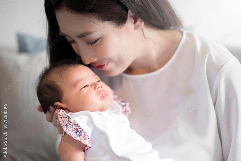 Beautiful woman holding a newborn baby in her arms Beautiful woman holding a newborn baby in her arms