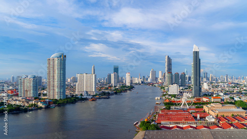 Obraz na płótnie Aerial view of the ferris wheel, Asiatique The Riverfront, near Chao Phraya River with skyscraper buildings in Bangkok Downtown at sunset, urban city, Thailand
