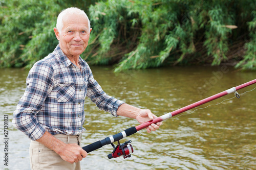 Mature man angling at riverside