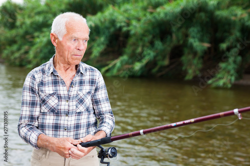 Mature man angling at riverside