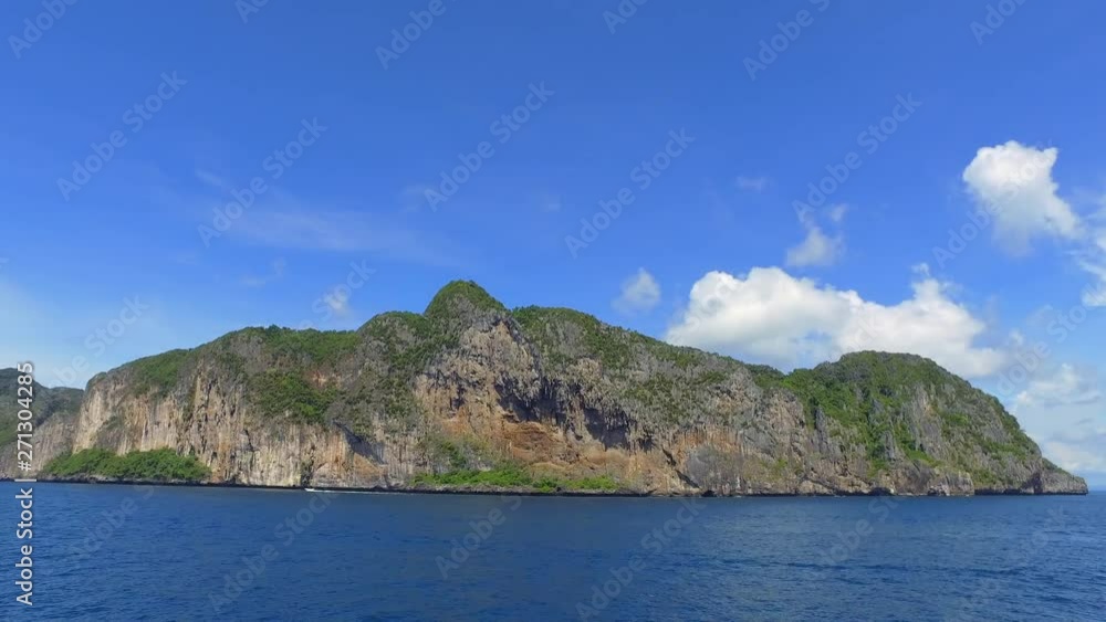 Distant Speedboat Passing Island with Rocky Cliffs in Blue Ocean - Ko Tao, Thailand Distant Speedboat Passing Island with Rocky Cliffs in Blue Ocean - Ko Tao, Thailand