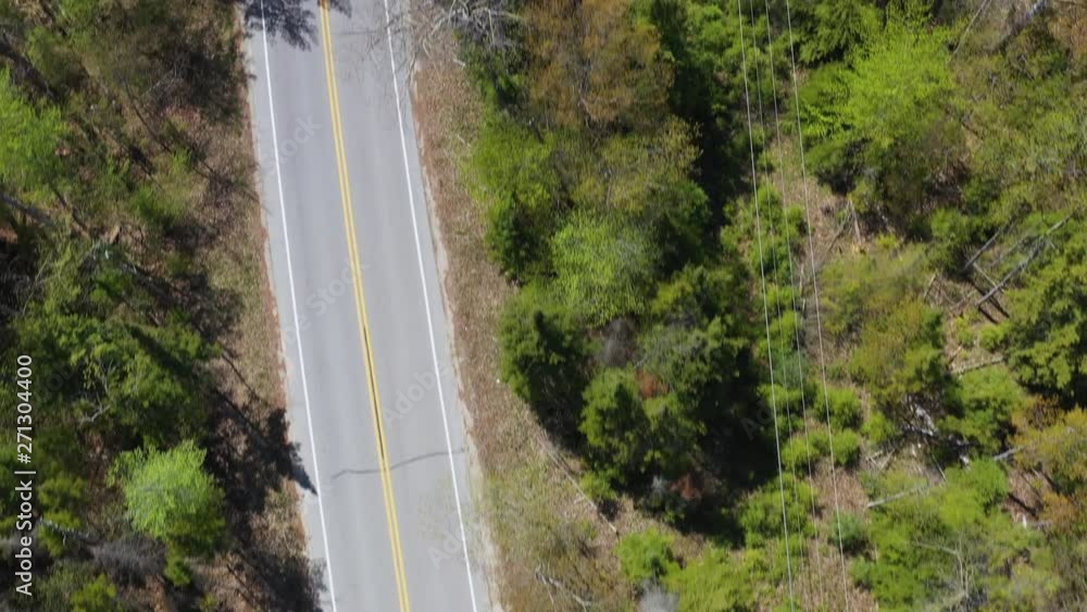 Flying low above asphalt curve road in Wisconsin, Door County. Aerial overhead view Flying low above asphalt curve road in Wisconsin, Door County. Aerial overhead view