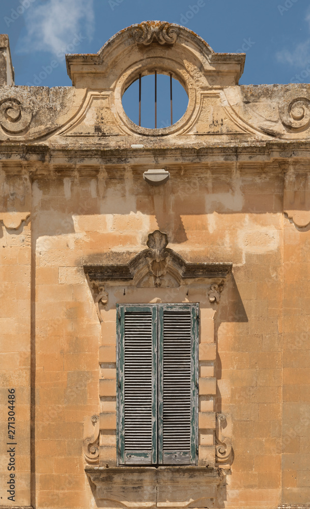 Naklejka premium Ventana con contraventana en la fachada de un edificio histórico, en la ciudad de Lecce en Italia