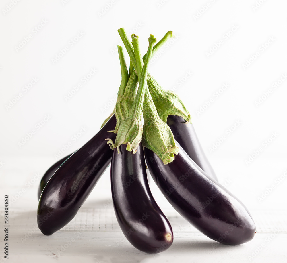 Fresh eggplants on a white wooden table. Fresh eggplants on a white wooden table.