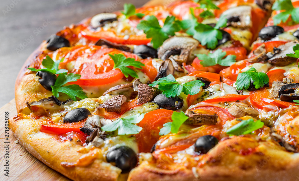 sliced Pizza with Mozzarella cheese, Tomatoes, pepper, olive, mushrooms, Spices and Fresh leaf. Italian pizza on wooden table background sliced Pizza with Mozzarella cheese, Tomatoes, pepper, olive, mushrooms, Spices and Fresh leaf. Italian pizza on wooden table background