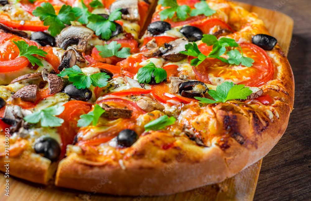 sliced Pizza with Mozzarella cheese, Tomatoes, pepper, olive, mushrooms, Spices and Fresh leaf. Italian pizza on wooden table background sliced Pizza with Mozzarella cheese, Tomatoes, pepper, olive, mushrooms, Spices and Fresh leaf. Italian pizza on wooden table background
