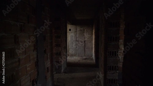 Old, scary, abandoned house interior. Wooden door at the end of scary concrete corridor. Architecture structure