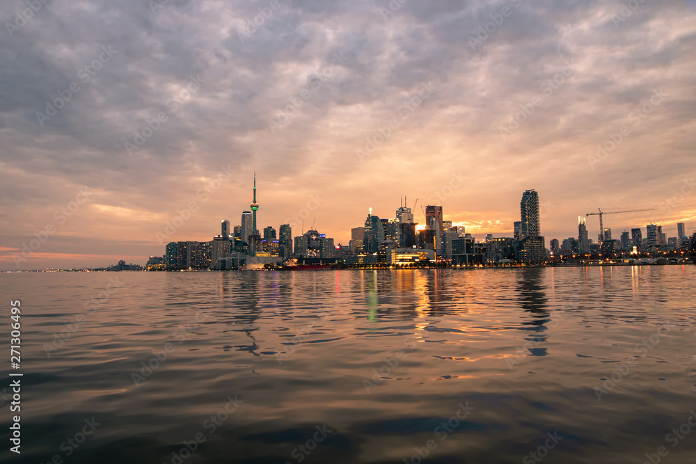 Toronto skyline reflecting in lake Ontario during a beautiful vibrant sunset. 