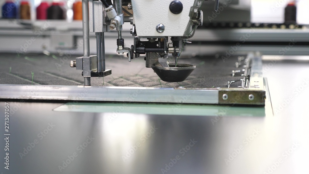 Robotics works in tailoring production line. Robot sewing machine. an automated machine embroidery pattern with red threads on a black cloth. automatic sewing machine.
