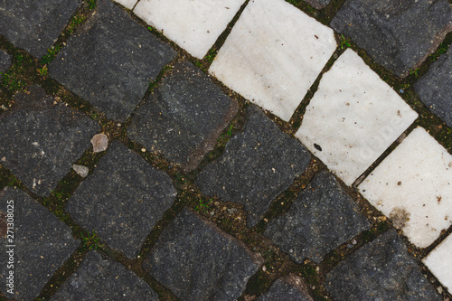 Closeup shot of grey and white square pavement     Rough stone blocks used for decorative purposes in the construction of alleys and sidewalks
