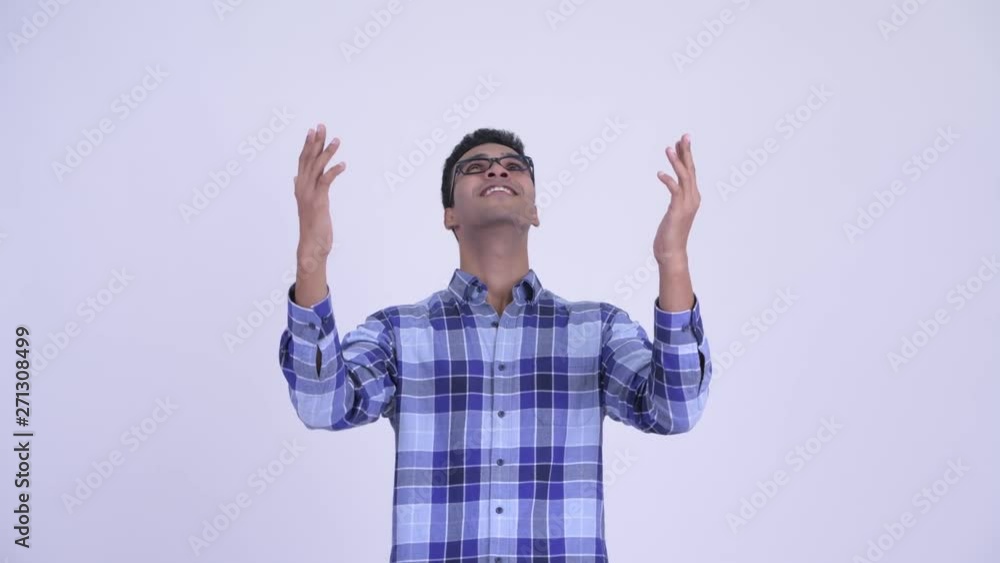 Happy young Indian hipster man catching something Happy young Indian hipster man catching something