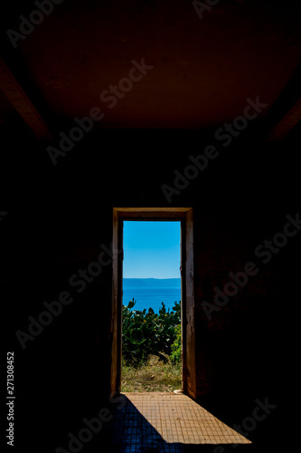 window of an old abandoned building overlooking the sea