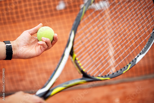 Tennis player prepares to serve ball during tennis match © NDABCREATIVITY