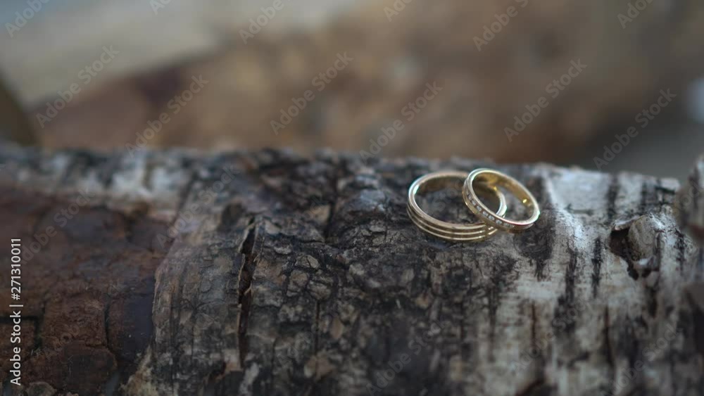 Macro shot of two golden rings on top of a log with smoke blowing Macro shot of two golden rings on top of a log with smoke blowing