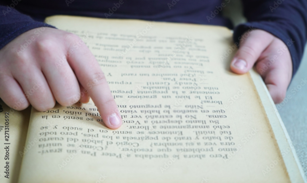 Fototapeta premium dedo de niña sobre texto de un libro