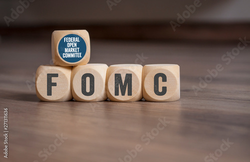 Cubes dice with FOMC Federal Open Market Committee on wooden background