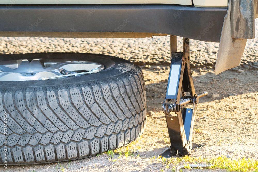 Replacement wheels on the highway, the car is jacked, there is a spare wheel Replacement wheels on the highway, the car is jacked, there is a spare wheel