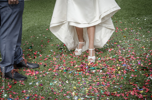 Bride shoes stepping on confetti on the floor