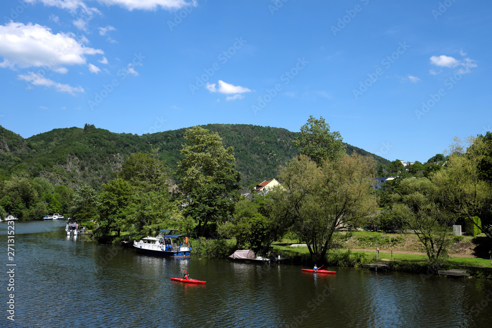 Fototapeta premium 2 Kanufahrer mit roten Paddelbooten auf der Lahn bei Lahnstein - Stockfoto