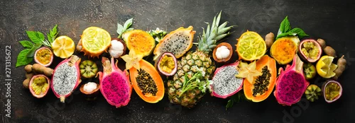 Obraz  z motywem Tropical fruits on a brown background: papaya, mangosteen, cactus fruit, pytahaya, pineapple. Top view. Free space for text.
