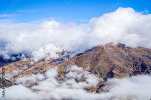 Low clouds or fog (inversion) above lake Wakatipu and Queenstown valley. View of the scenic road and snow covered peaks of Single cone, Cecil Peak and Mount Nicholas. Panoramic landscape. New Zealand. © Dajahof