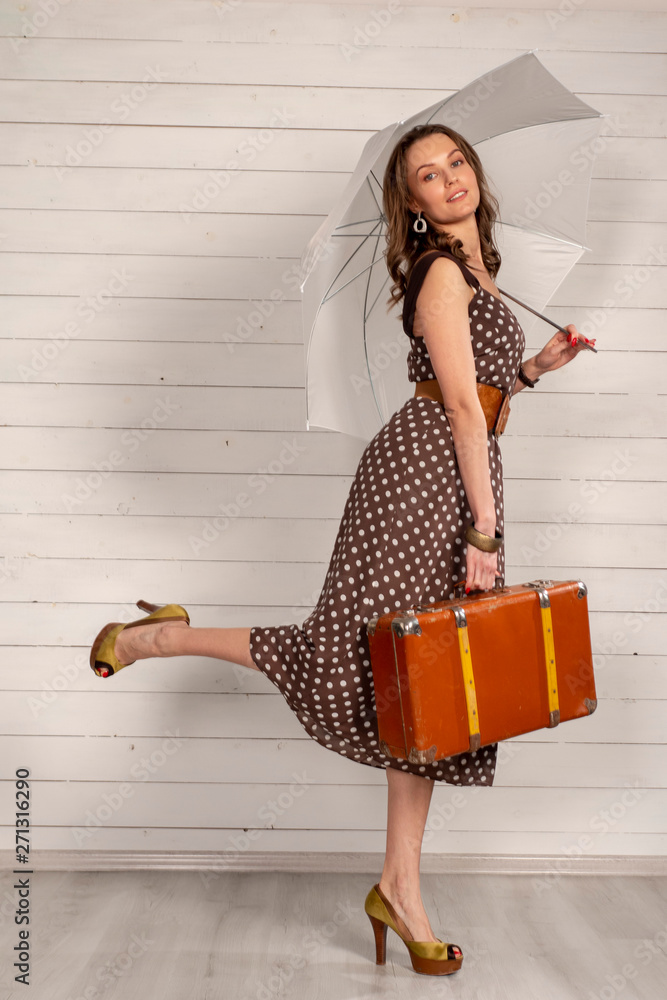 Girl in polka-dot dress with retro suitcase and umbrella. Mary Poppins  style. Stock-foto | Adobe Stock