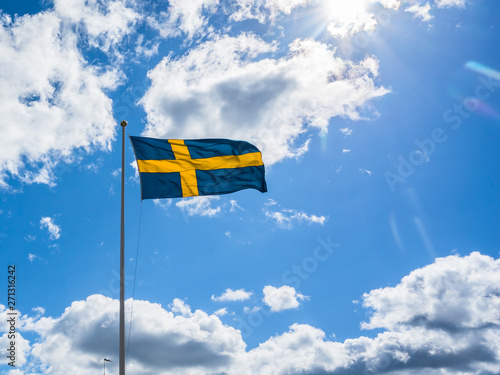 Swedish Flag on blue sky white clouds. Swedish Flag Day concept. . Sveriges nationaldag. National Day of Sweden. Swedish Flag Day. 