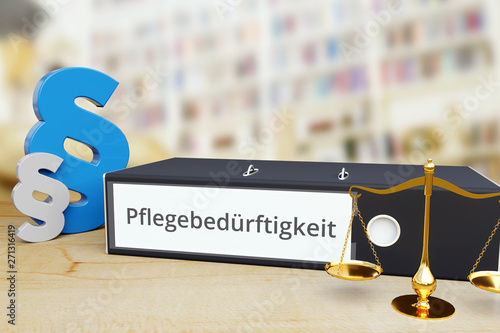 Pflegebedürftigkeit – Recht/Gesetz. Ordner auf Schreibtisch mit Beschriftung neben Paragraf und Waage. Anwalt