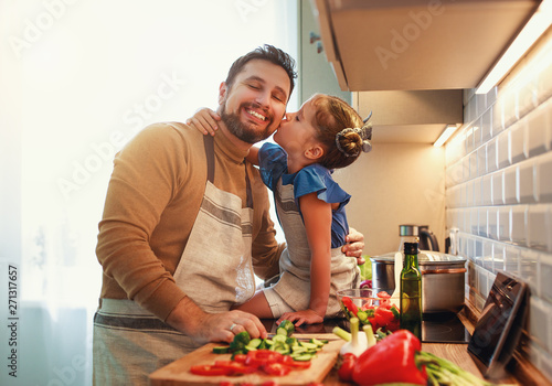 happy family father with child daughter preparing vegetable salad .