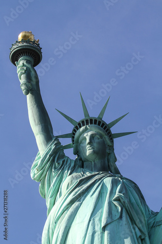 statue of liberty in new york with torch - close up with blue sky © c-foto