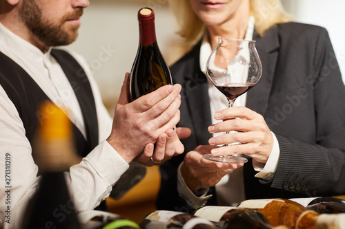 Obraz na płótnie Close up portrait of two professional sommeliers choosing wine in cellar or wine