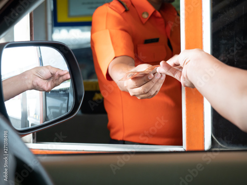 Selective focus at hand driver pay fee for the expressway. People pays money to a cashier for a toll road, toll gate or motorway entrance. photo