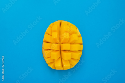 Fresh mango. On blue background half of fresh mango. Top view, copy space