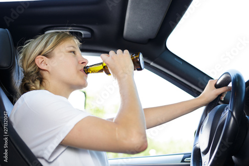 young woman drinking alcohol while driving © auremar