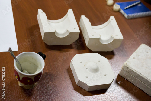 meeting potters. training courses for novice ceramists. the master potter with 15 years of experience shows a gypsum plaster mold for making many ceramic cups. reportage.