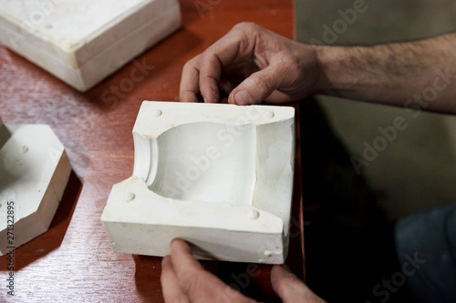 meeting potters. training courses for novice ceramists. the master potter with 15 years of experience shows a gypsum plaster mold for making many ceramic cups. reportage.