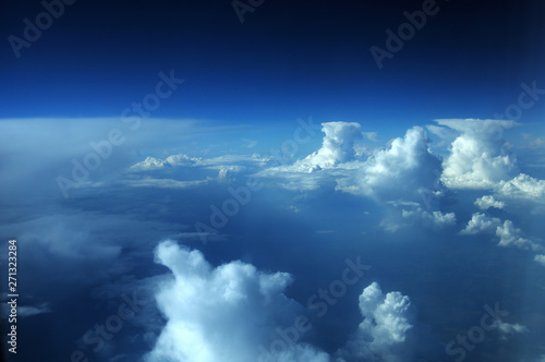aerial view from plane, blue sky with clouds and sun © Евгений Кожевников